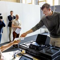 Emmanuel de Bélgica coge su documento de identidad tras haber votado por primera vez