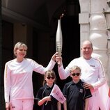 Alberto y Charlene de Mónaco y sus hijos Jacques y Gabriella con la antorcha olímpica de París 2024