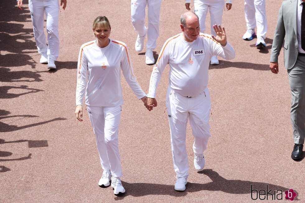 Alberto y Charlene de Mónaco cogidos de la mano y vestidos a juego con un chándal blanco
