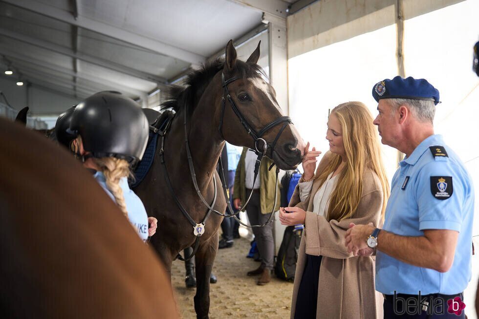 Amalia de Holanda acariciando a un caballo de la Escolta de Caballería