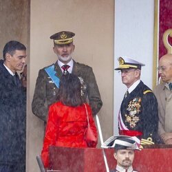 El Rey Felipe junto a Pedro Sánchez y Margarita Robles en pleno momento de lluvia en el Día de la Hispanidad 2024