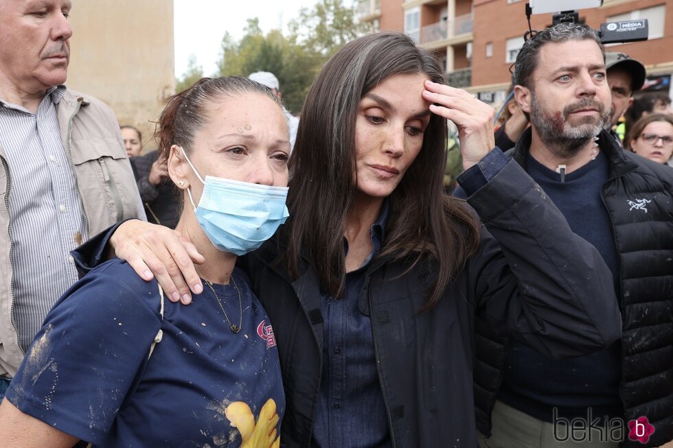 La Reina Letizia con gesto serio junto a una mujer en Paiporta durante su visita a las zonas afectadas por la DANA en Valencia