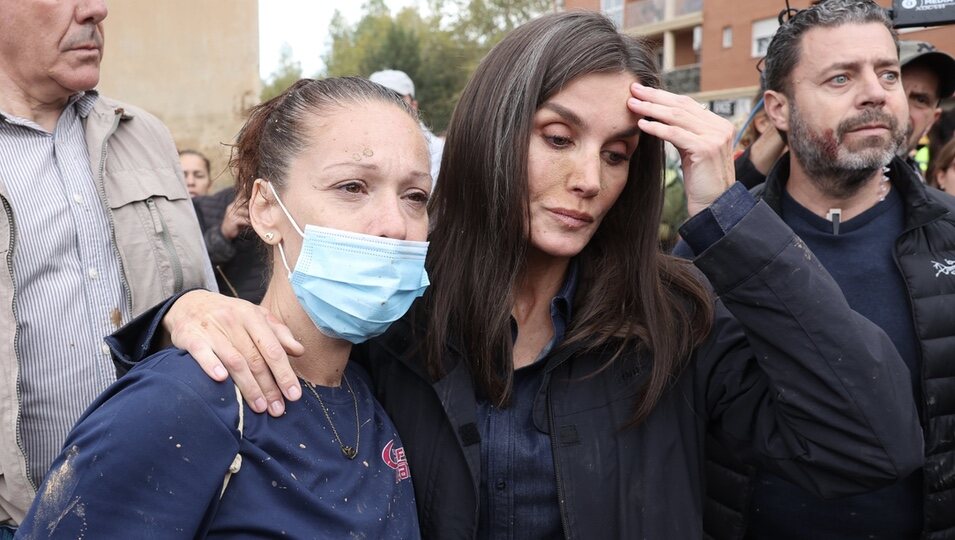 La Reina Letizia con gesto serio junto a una mujer en Paiporta durante su visita a las zonas afectadas por la DANA en Valencia