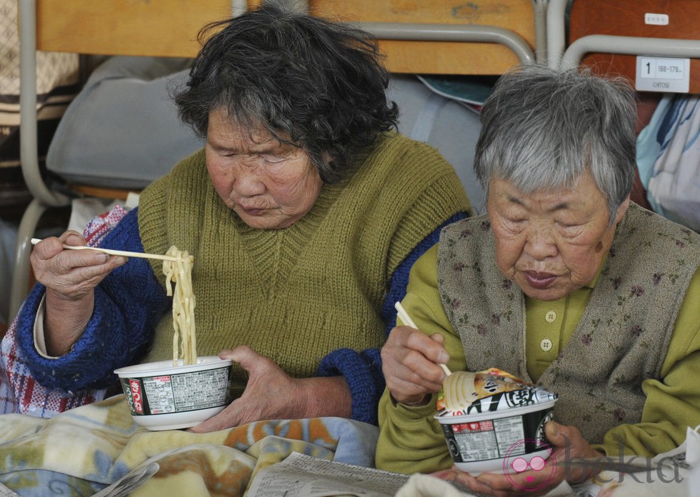 Dos ancianas almuerzan tras ser evacuadas por el tsunami de Japón