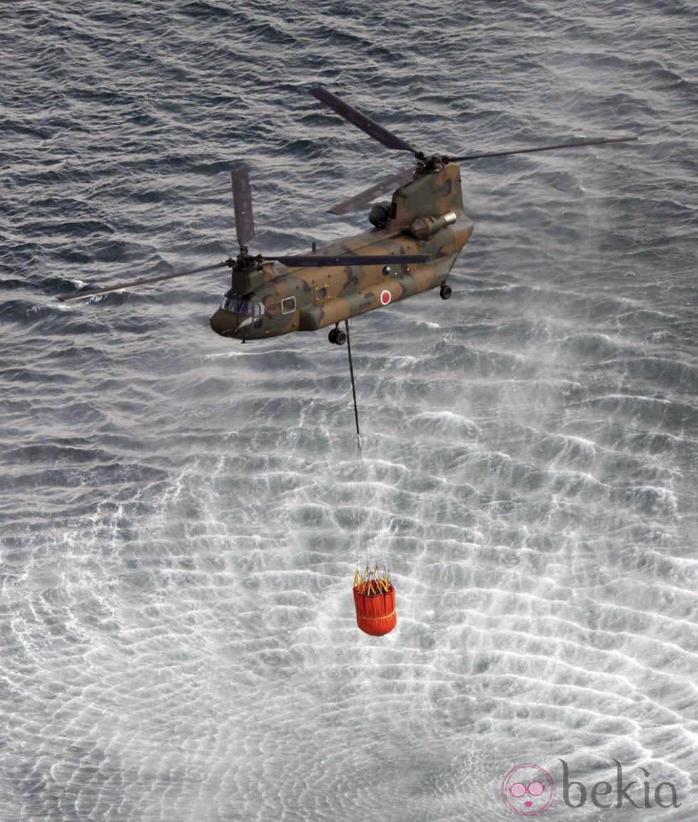 Un helicóptero recoge agua de mar para echarla en un reactor de Fukushima