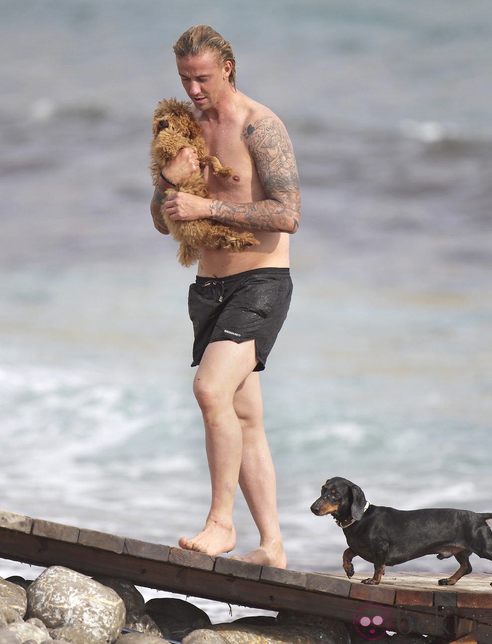 Guti sale del mar con su perro en Ibiza