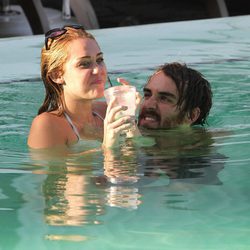 Miley Cyrus en bikini se divierte en la piscina con un amigo