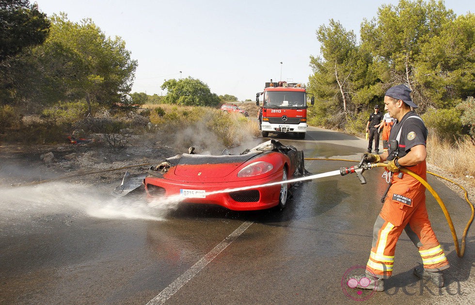 Un bombero apaga el Ferrari calcinado de Ever Banega
