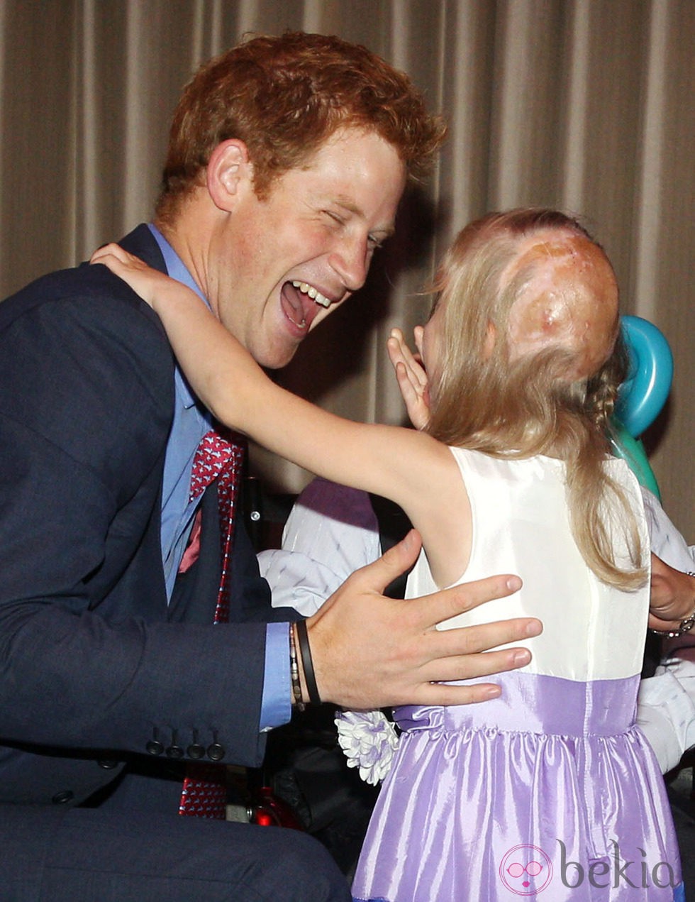 El Príncipe Harry abraza a una niña en los premios de la Fundación Wellchild