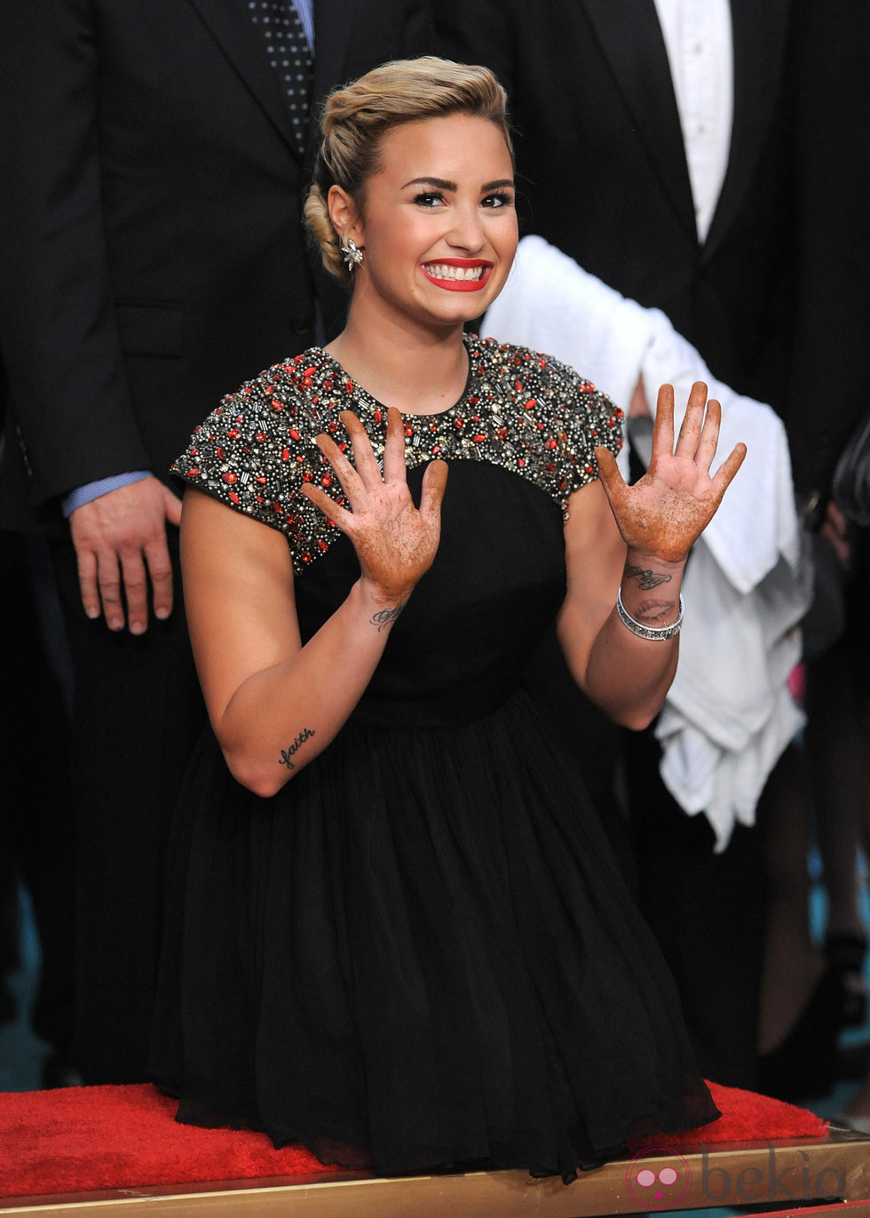 Demi Lovato muestra sus manos tras dejar sus huellas en el Teatro Chino Grauman