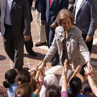 La Reina Sofía saluda a unos niños durante su visita a los afectados por las inundaciones en Málaga