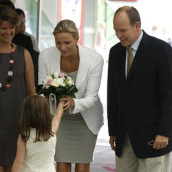 Charlene recibe un ramo de flores bajo la atenta mirada de Alberto de Mónaco