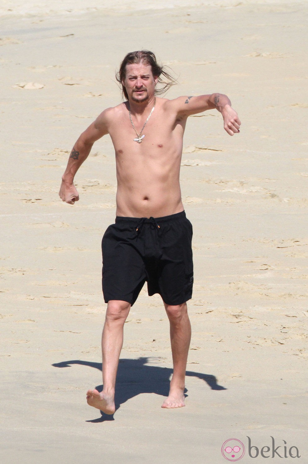 Kid Rock trota por la playa con el torso desnudo