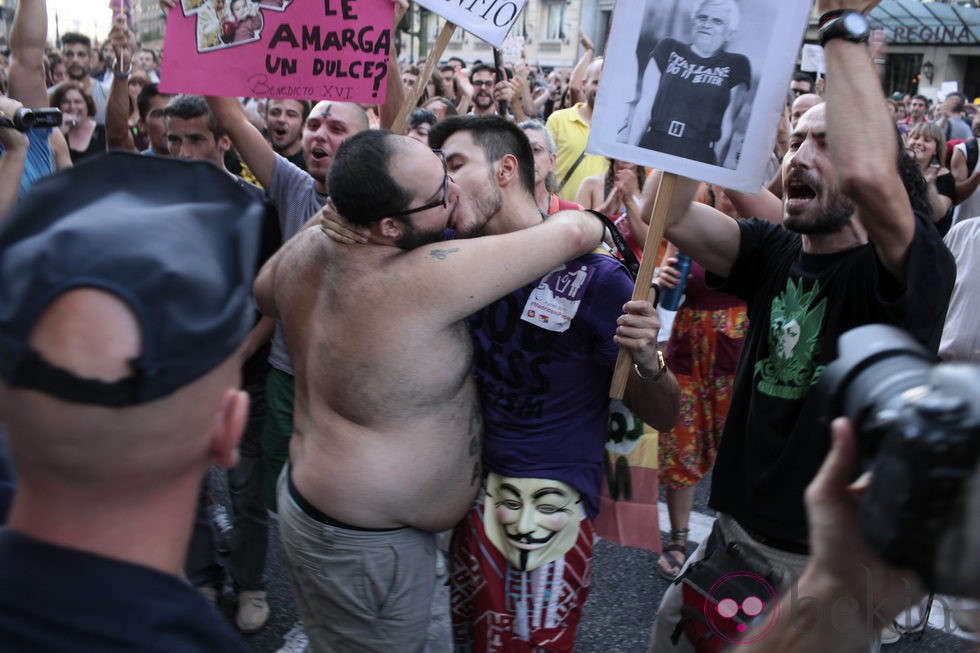 Dos hombres se besan en la marcha laica