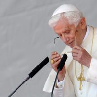 El Papa Benedicto XVI se pone las gafas para leer su discurso en Madrid-Barajas