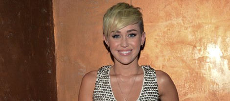 Miley Cyrus con una falda larga color crema y chaleco con tachuelas