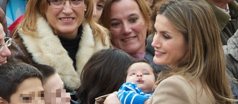 La Princesa de Asturias con un bebé en brazos durante su visita a Caspe