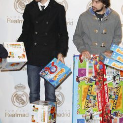 Rudy Fernández y Sergio Llul repartiendo regalos de Navidad a los niños