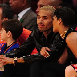 Rihanna agarrada a Chris Brown durante el partido de la NBA