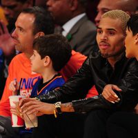 Rihanna agarrada a Chris Brown durante el partido de la NBA