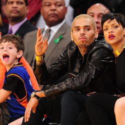 Rihanna y Chris Brown viendo concentrados el partido de la NBA