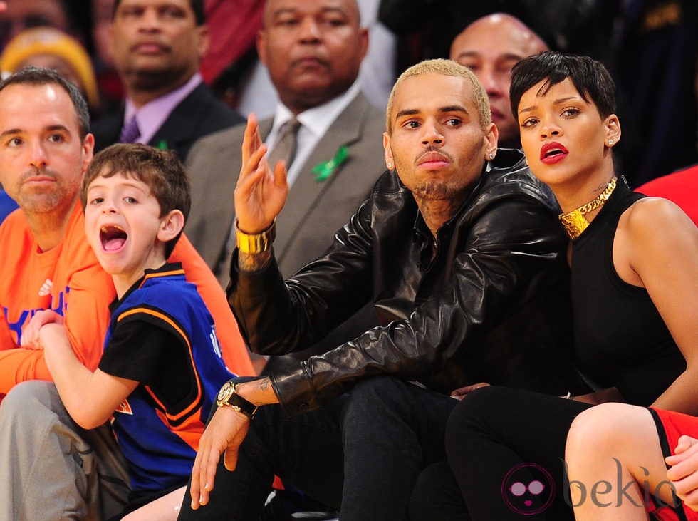 Rihanna y Chris Brown viendo concentrados el partido de la NBA