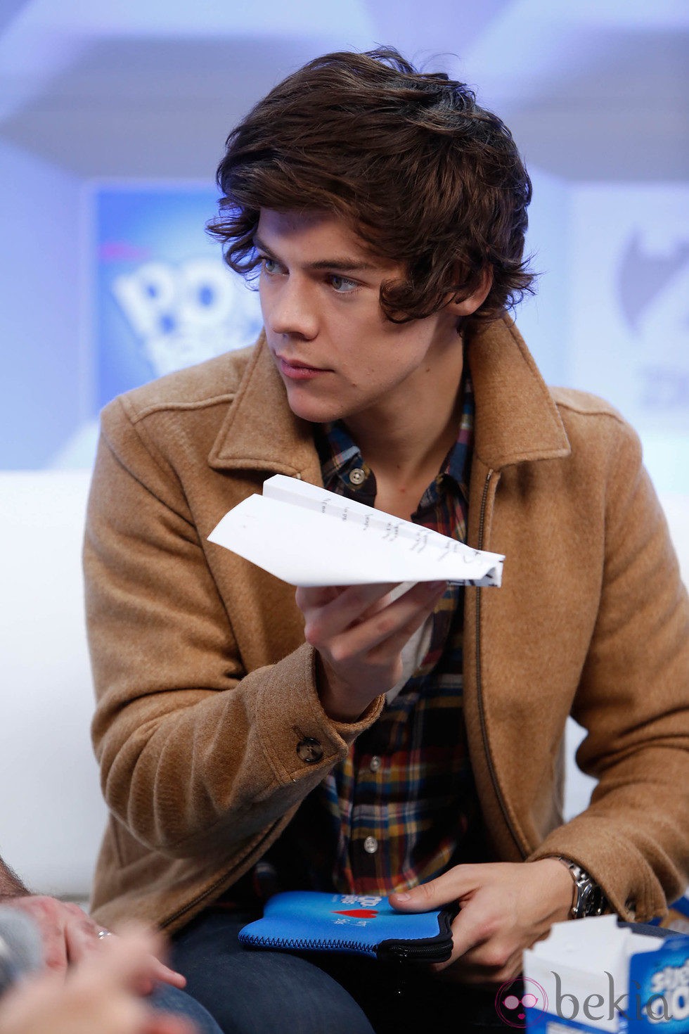 Harry Styles con un avión de papel