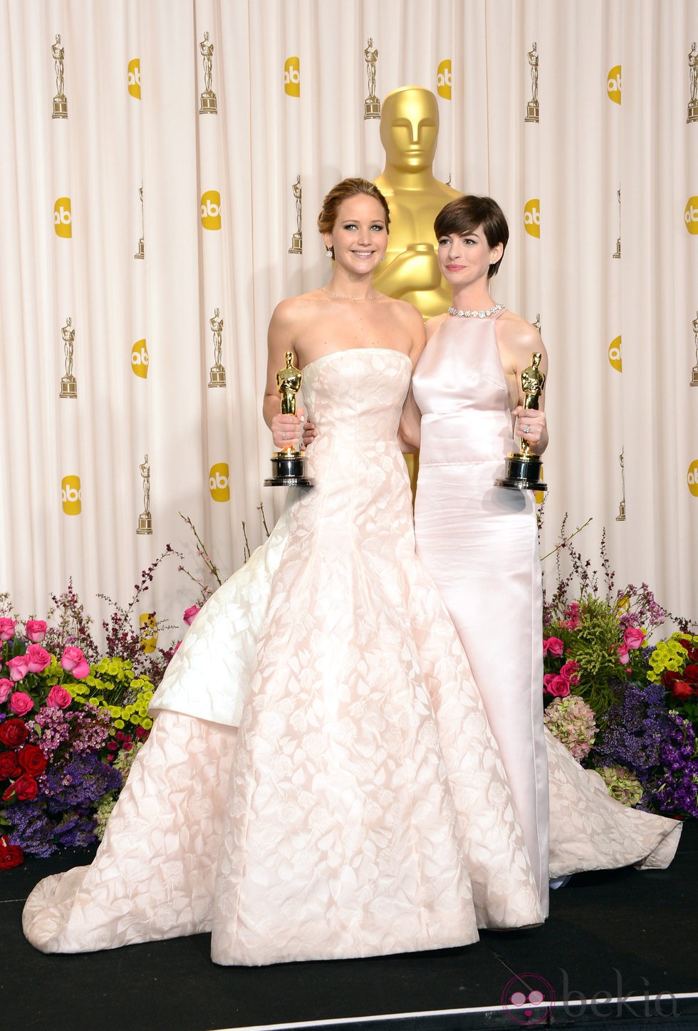 Jennifer Lawrence y Anne Hathaway posando con sus galardones en los Oscar 2013