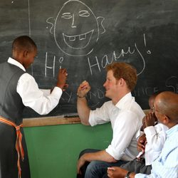 Un niño escribe en la pizarra junto al Príncipe Harry en Lesotho