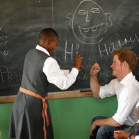 Un niño escribe en la pizarra junto al Príncipe Harry en Lesotho
