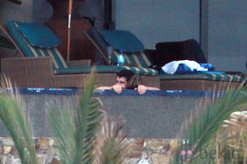 Nick Jonas y Delta Goodrem abrazados en la piscina