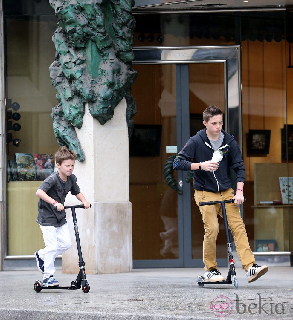 Brooklyn y Cruz Beckham montando en patinete por las calles de París