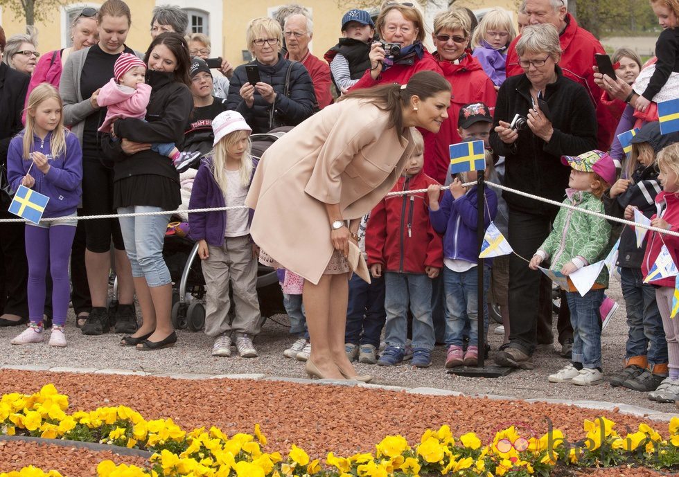 Victoria de Suecia saluda a unos niños en la inauguración de una exposición sobre la Princesa Estela