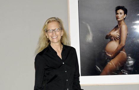 Annie Leibovitz posando con su fotografía de Demi Moore desnuda embarazada