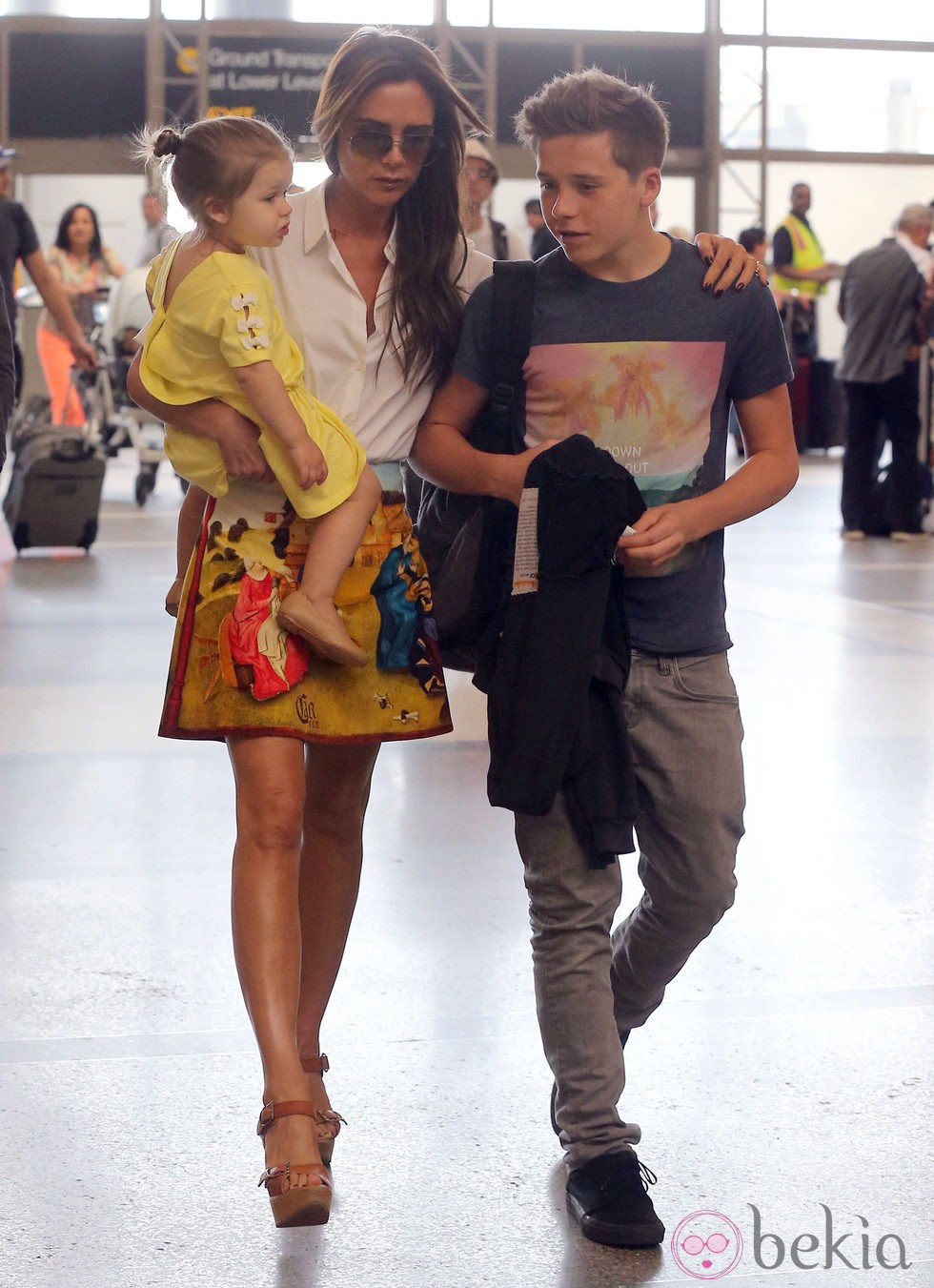 Victoria Beckham sujeta a Harper Seven y coge del hombro a Brooklyn en el aeropuerto