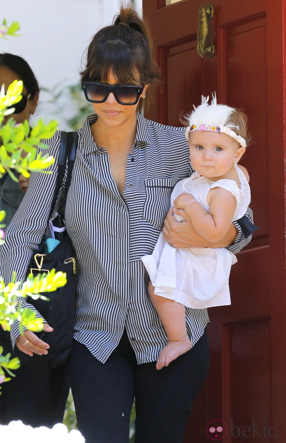 Kourtney Kardashian con su hija Penélope luciendo un tocado de plumas