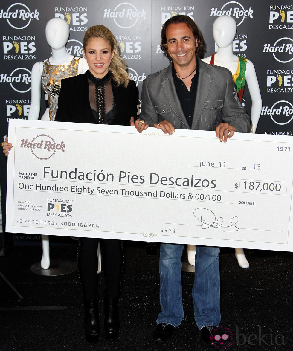 Tom Perez entrega un cheque a Shakira para la Fundación Pies Descalzos