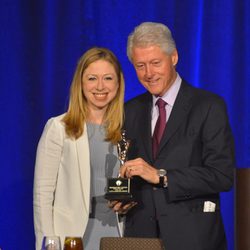 Bill Clinton con su hija Chelsea sosteniendo el galardón a 'Padre del Año'