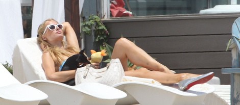 Paris Hilton tumbada al sol junto a sus perros en una playa de Malibú