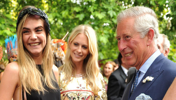 Carlos de Inglaterra conversa con Cara y Poppy Delevingne en una fiesta benéfica
