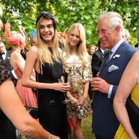 Carlos de Inglaterra conversa con Cara y Poppy Delevingne en una fiesta benéfica
