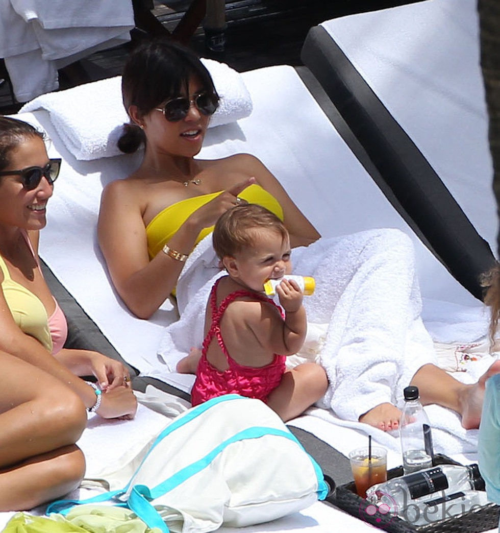 Kourtney Kardashian tumbada al sol con su hija Penelope Disick en una piscina de Miami