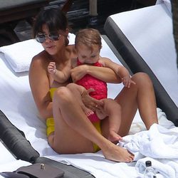 Kourtney Kardashian sostiene en brazos a su hija Penelope en una piscina de Miami