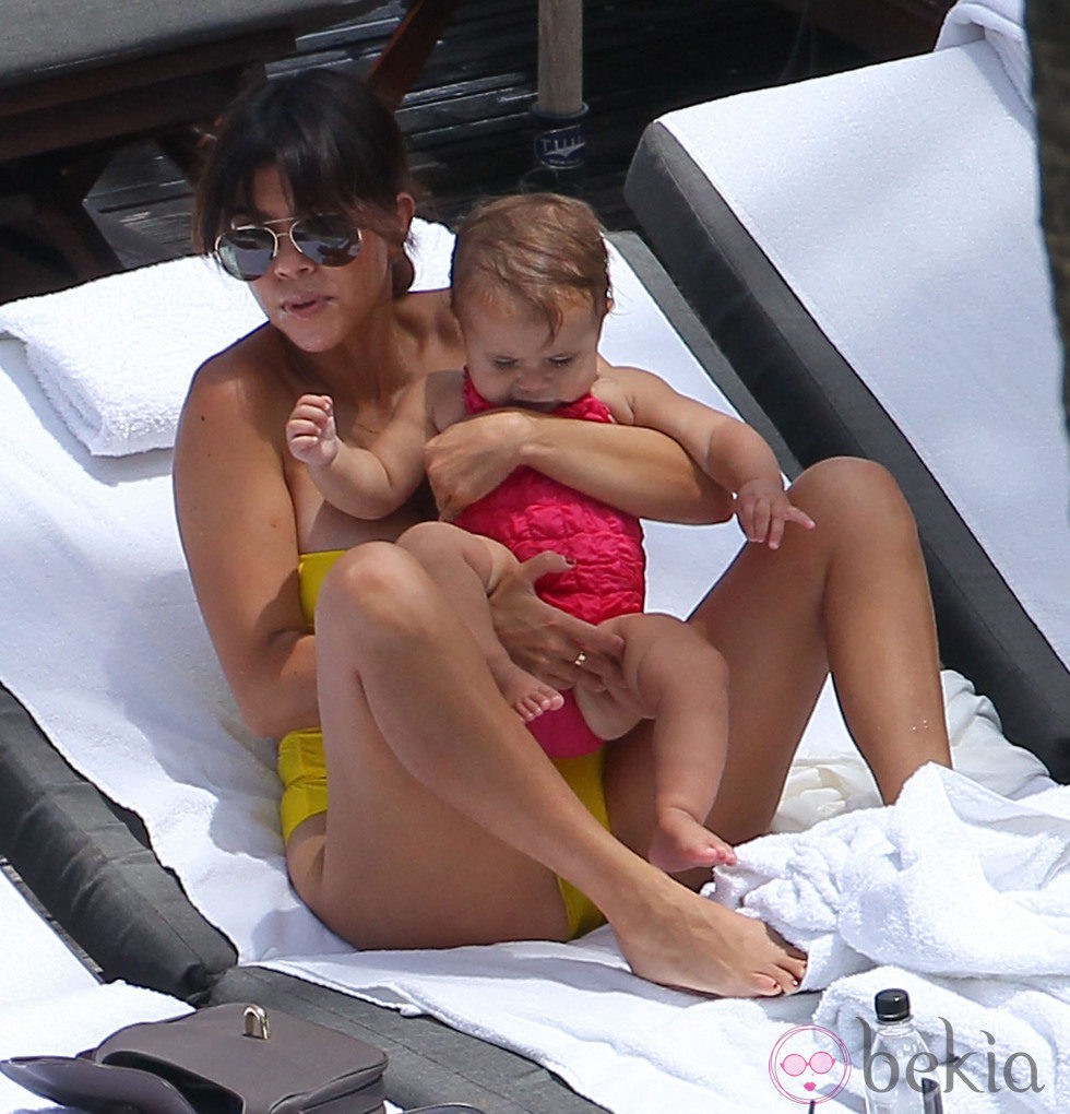 Kourtney Kardashian sostiene en brazos a su hija Penelope en una piscina de Miami