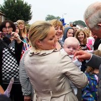 El Príncipe Carlos hace una carantoña a un niño antes de conocer a su primer nieto