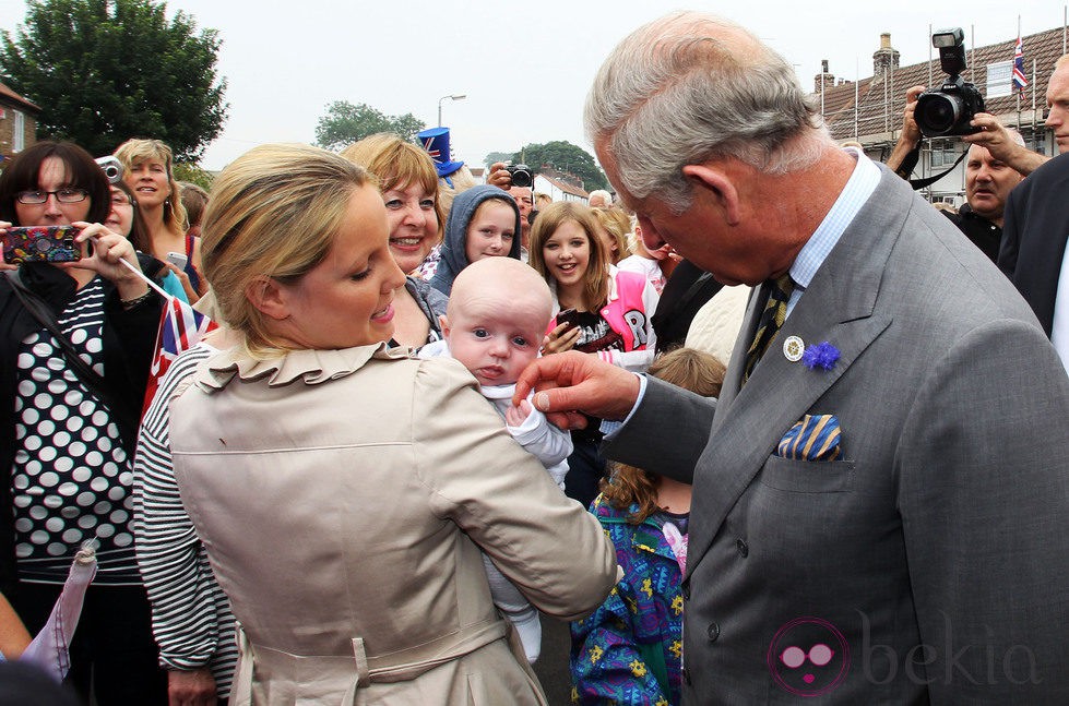 El Príncipe Carlos hace una carantoña a un niño antes de conocer a su primer nieto