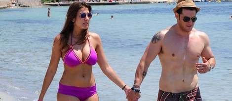 Manu Tenorio y Silvia Casas pasean cogidos de la mano por una playa de Ibiza