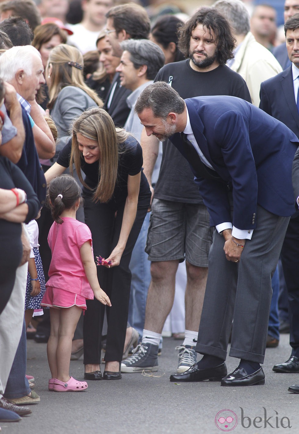 Los Príncipes Felipe y Letizia saludan a una niña en el lugar del accidente ferroviario