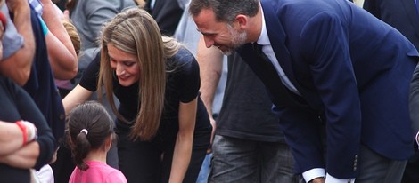 Los Príncipes Felipe y Letizia saludan a una niña en el lugar del accidente ferroviario