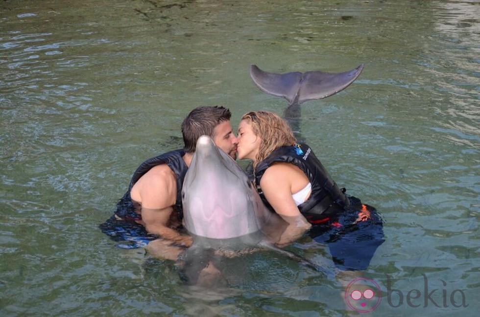 Gerard Piqué y Shakira besándose junto a un delfín